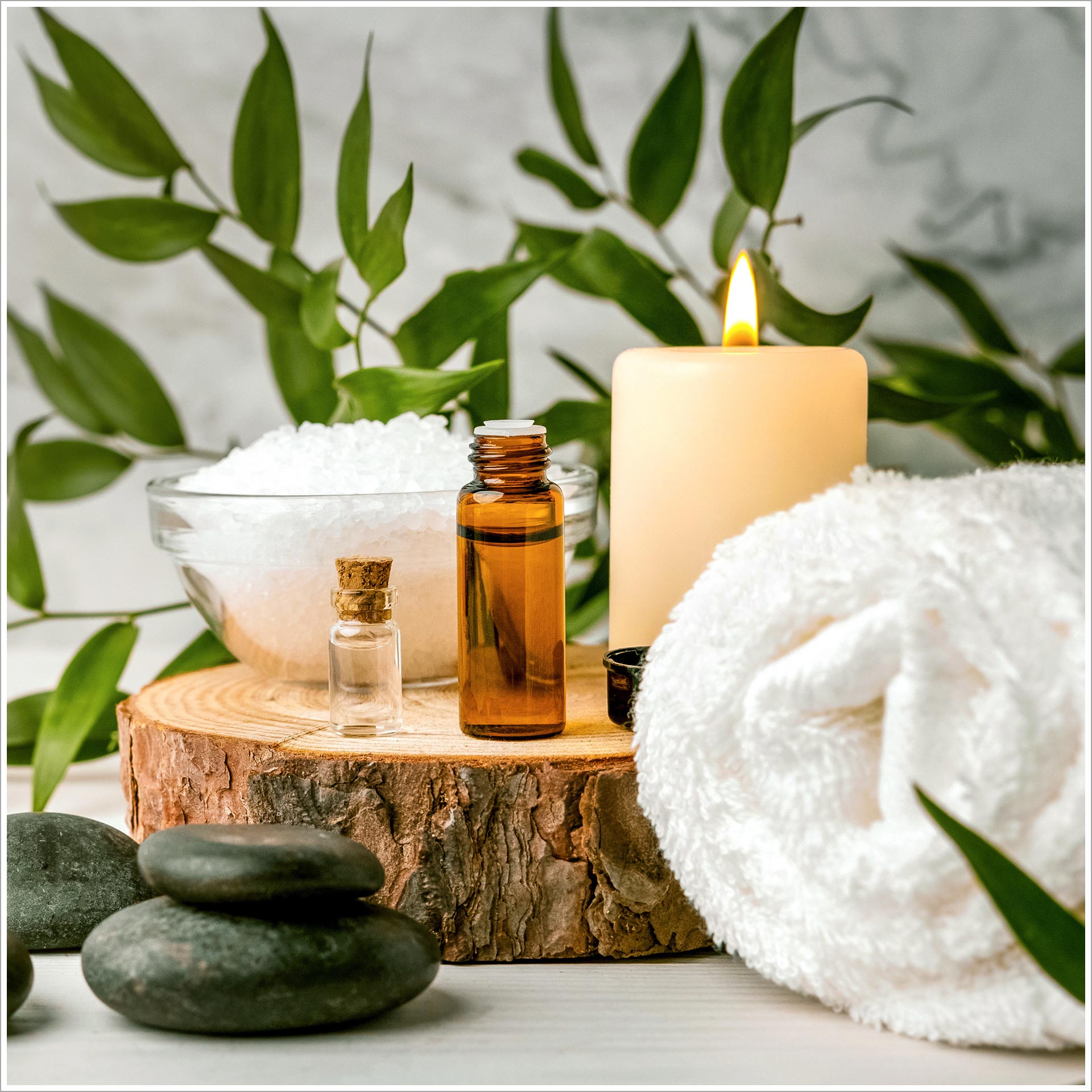 a candle and a towel with a bottle of oil