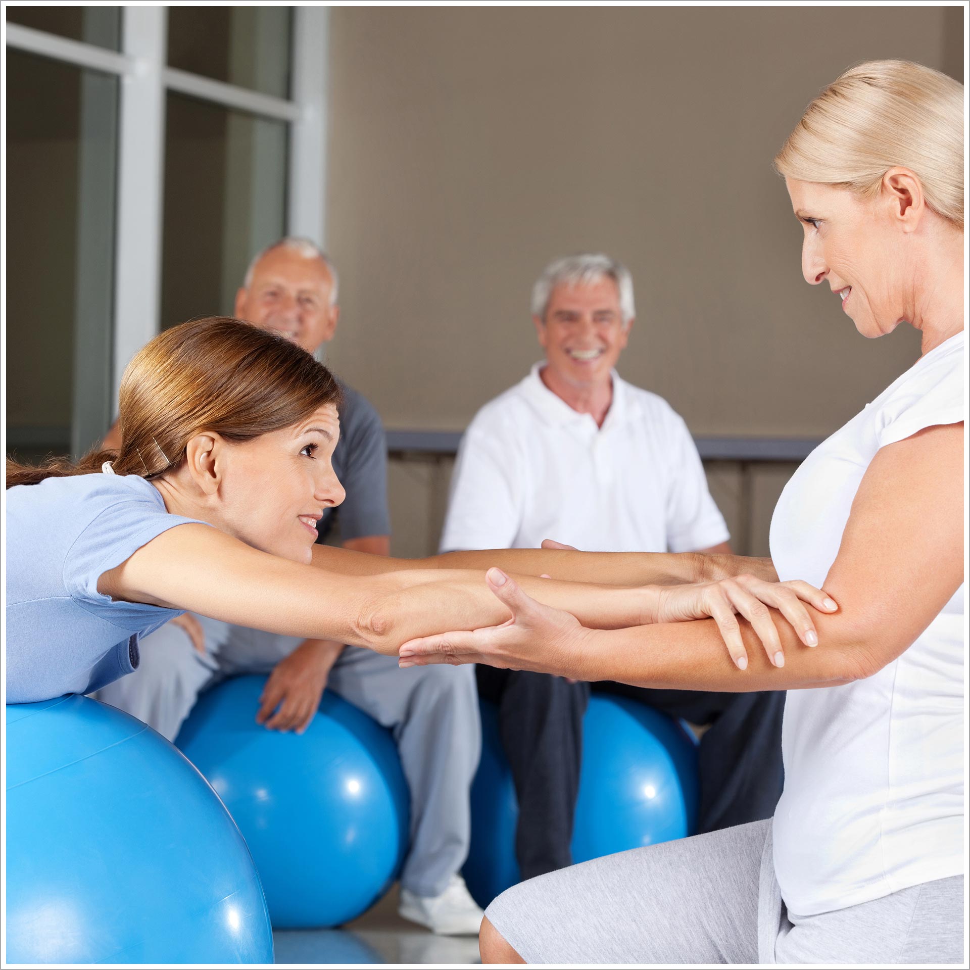 a woman helping another woman on exercise balls
